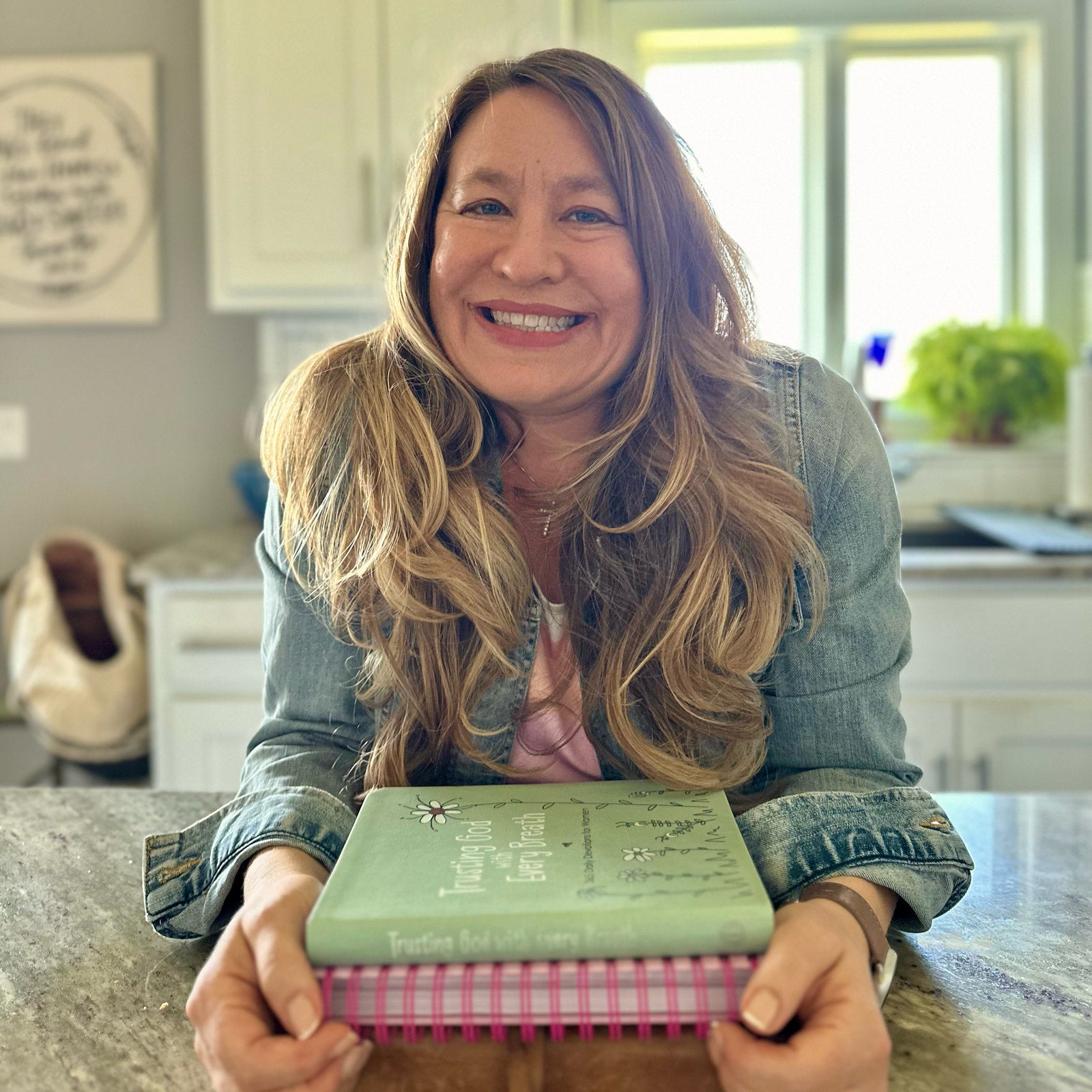 Amy Mecham smiling while holding her books